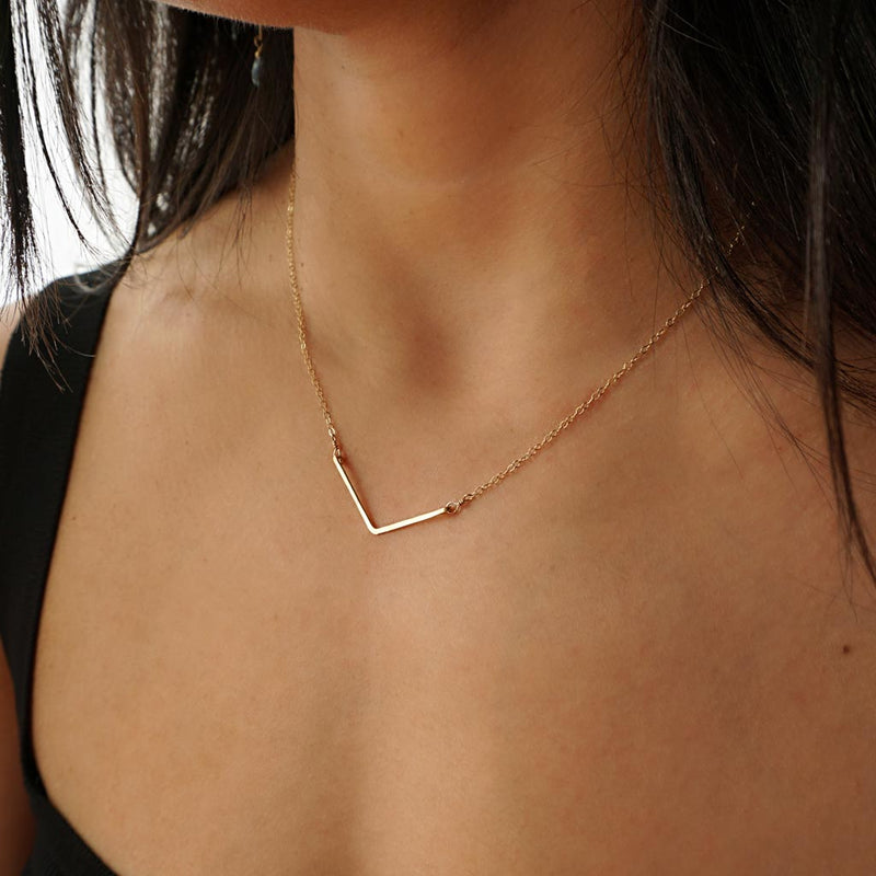 delicate gold v shaped pendant by delia langan jewelry