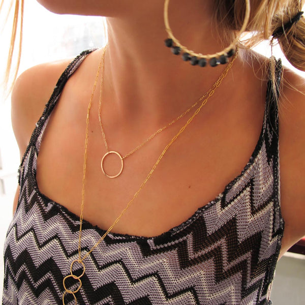 neckline with large gold circle necklace on gold chain